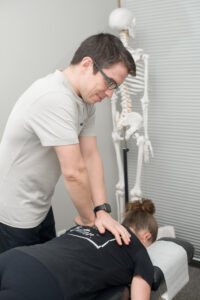 Chiropractor giving an upper back adjustment. Chiropractic care might be right for you.