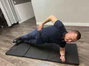 Man doing a side plank. One of the recommended exercises to promote core stability