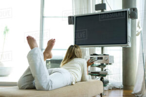 Woman lying on her stomach watching TV