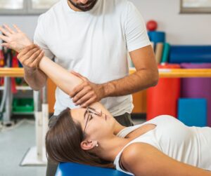 Chiropractor doing treatment on a woman's shoulder