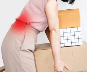 Woman lifting several boxes incorrectly and experiencing sciatica pain
