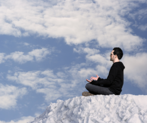 a man sitting on the top of an iceberg meditating 